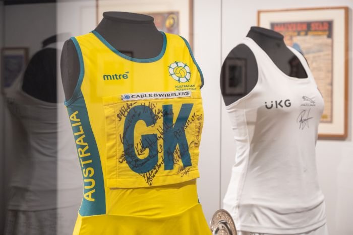 A mannequin with a yellow netball dress and a mannequin with a white tennis outfit